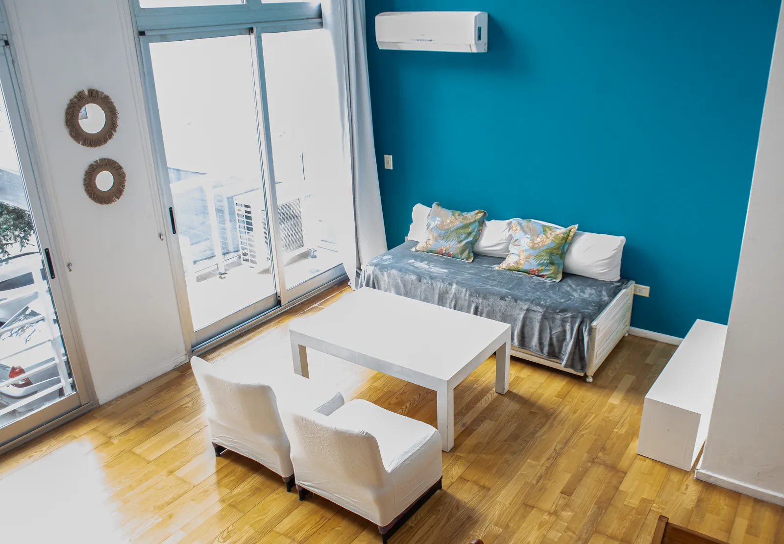 Living con sofá y comedor junto a los ventanales