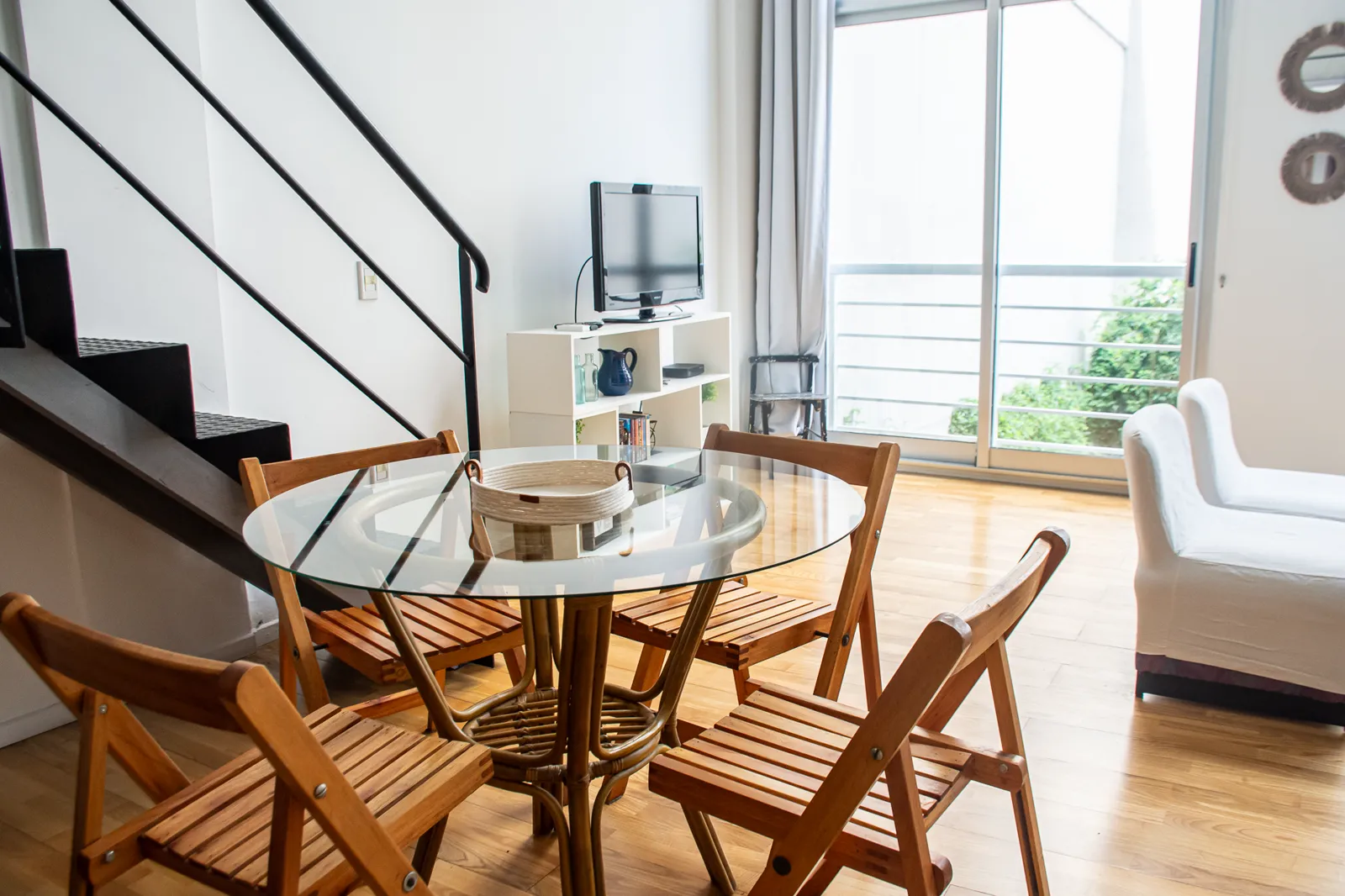 Comedor con mesa de vidrio junto a la escalera