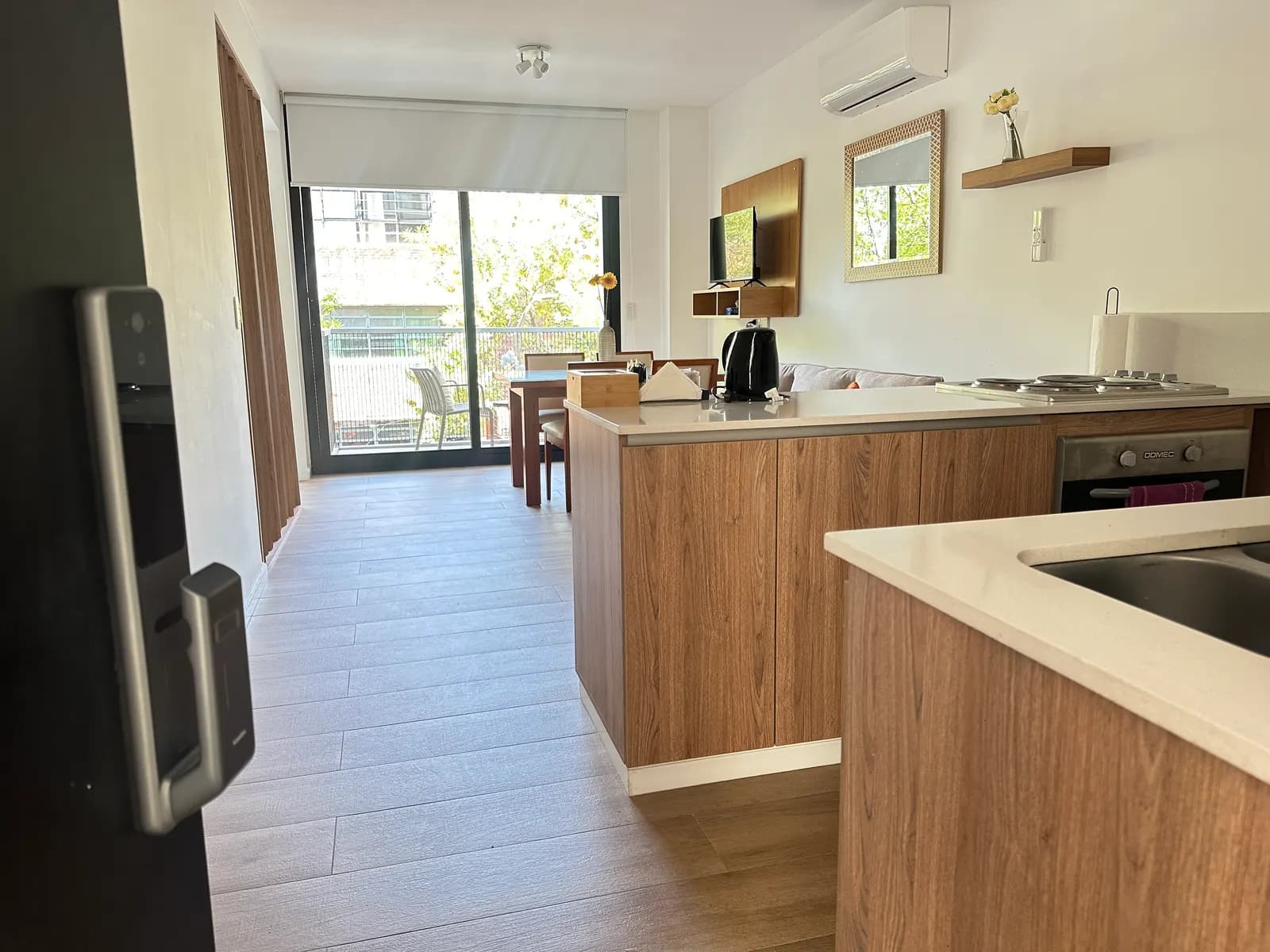 Cocina integrada con barra y comedor del departamento de Arribeños 2A, con salida al balcón