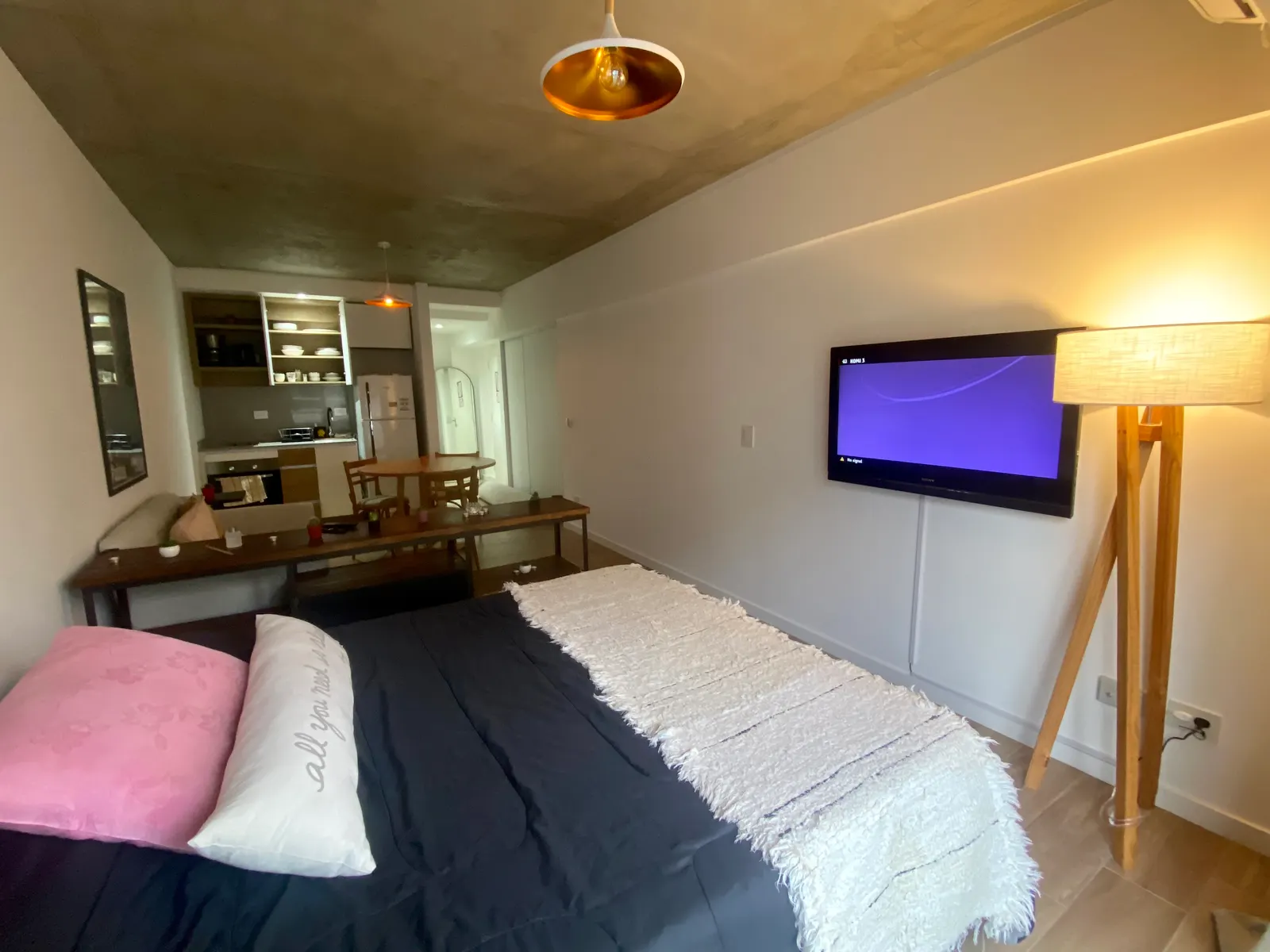 Monoambiente de Soler con cama de dos plazas, TV y cocina integrada al fondo